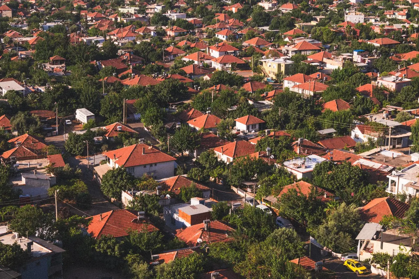 Aerial view of a neighborhood of red-tiled roofs and trees