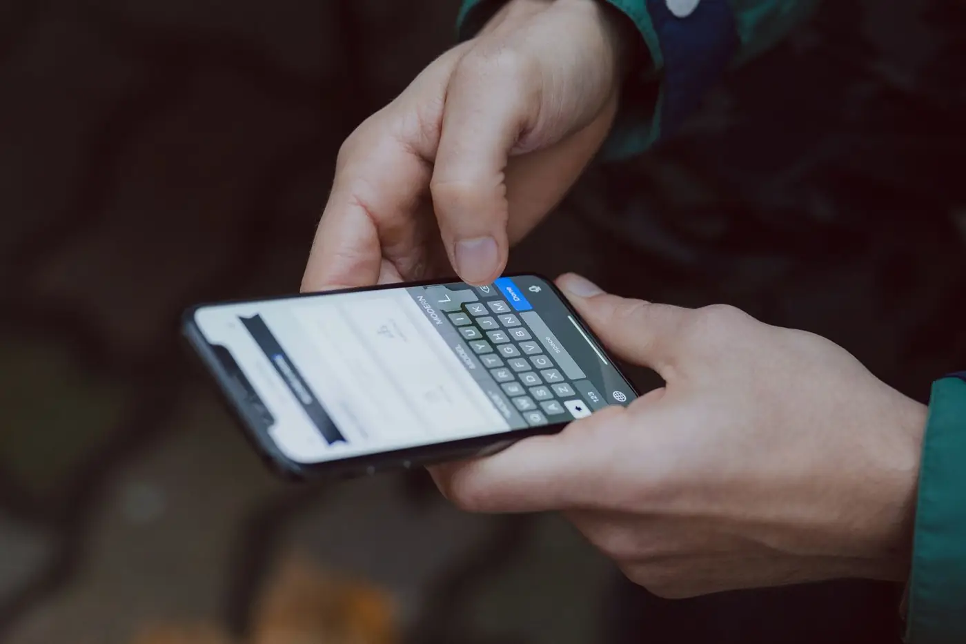 Hands typing a text message on a smartphone